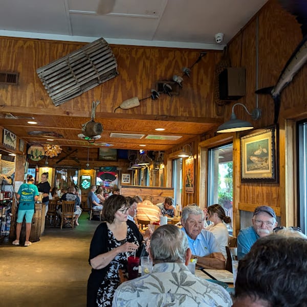 Diners enjoying meals in the rustic, wood-paneled interior of Graham's Landing seafood restaurant.