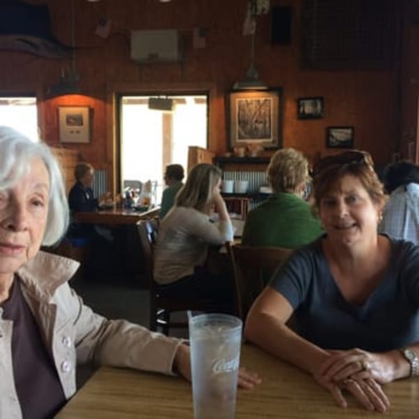 Two women at a table in a busy Graham's Landing seafood restaurant with other diners in the background.